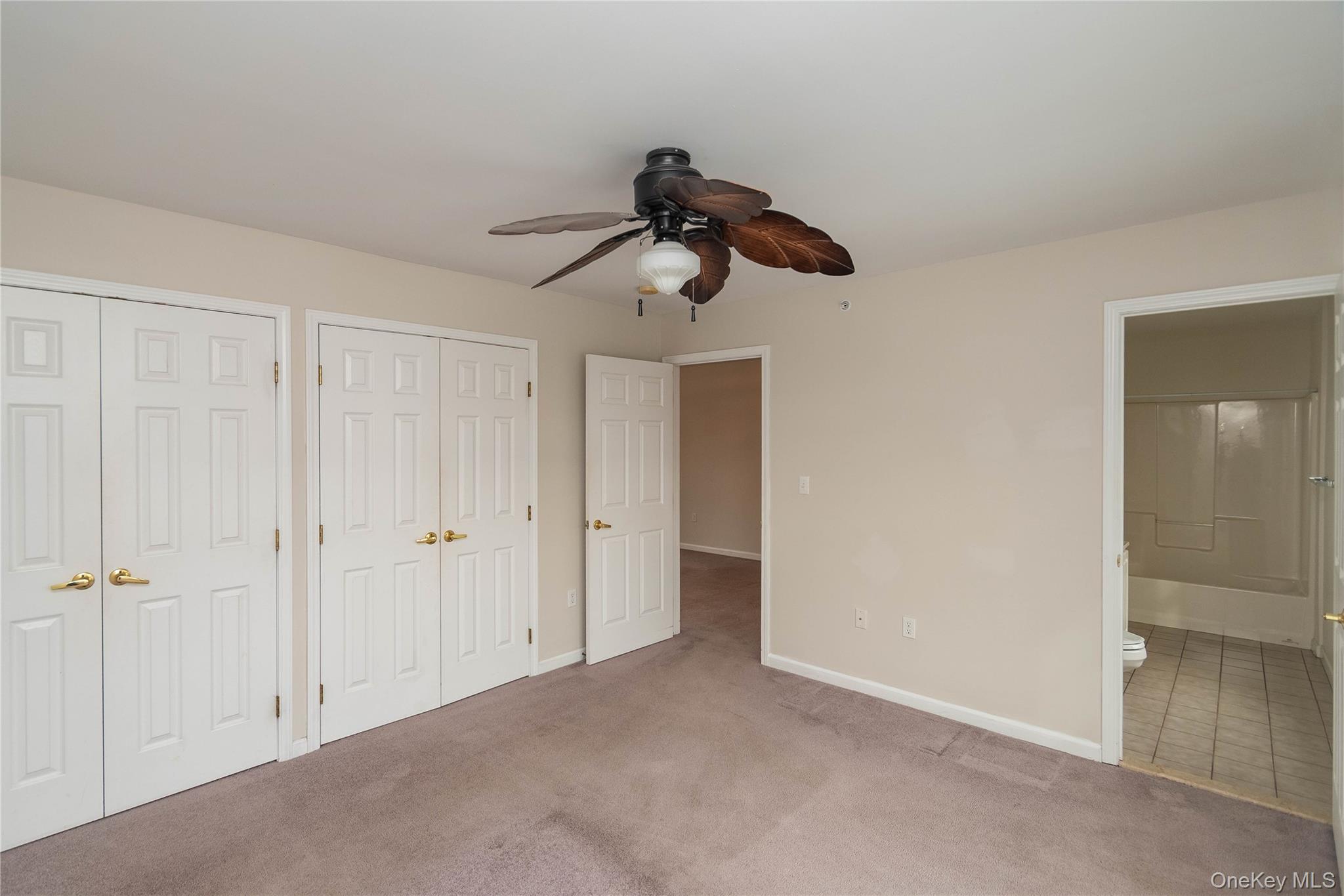 70 Aveonis Court Fishkill, NY 12524 - Photo 15 of 19 Unfurnished bedroom featuring multiple closets, carpet flooring, connected bathroom, and ceiling fan
