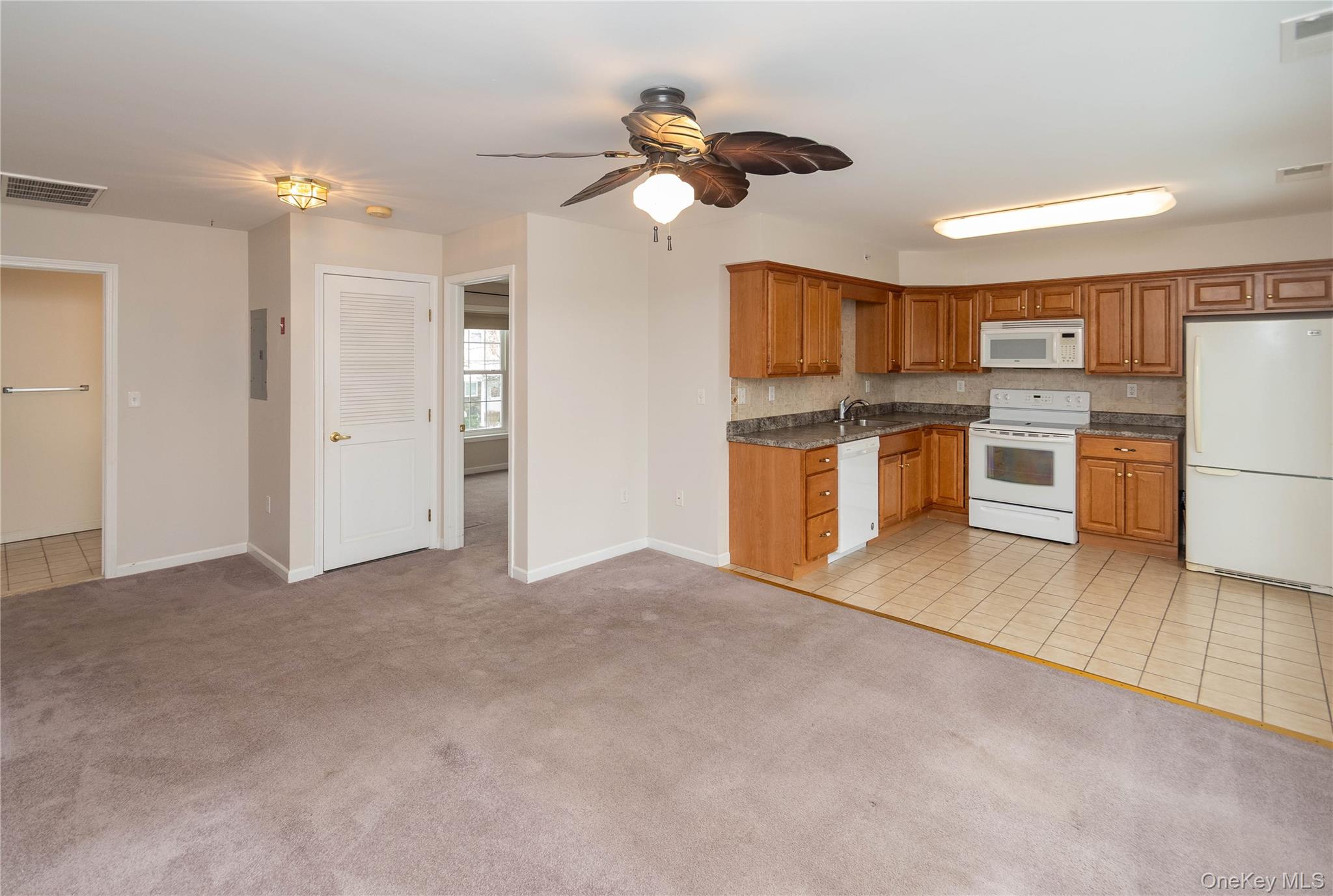 70 Aveonis Court Fishkill, NY 12524 - Photo 2 of 19 Kitchen with white appliances, light colored carpet, brown cabinetry, and light tile patterned floors