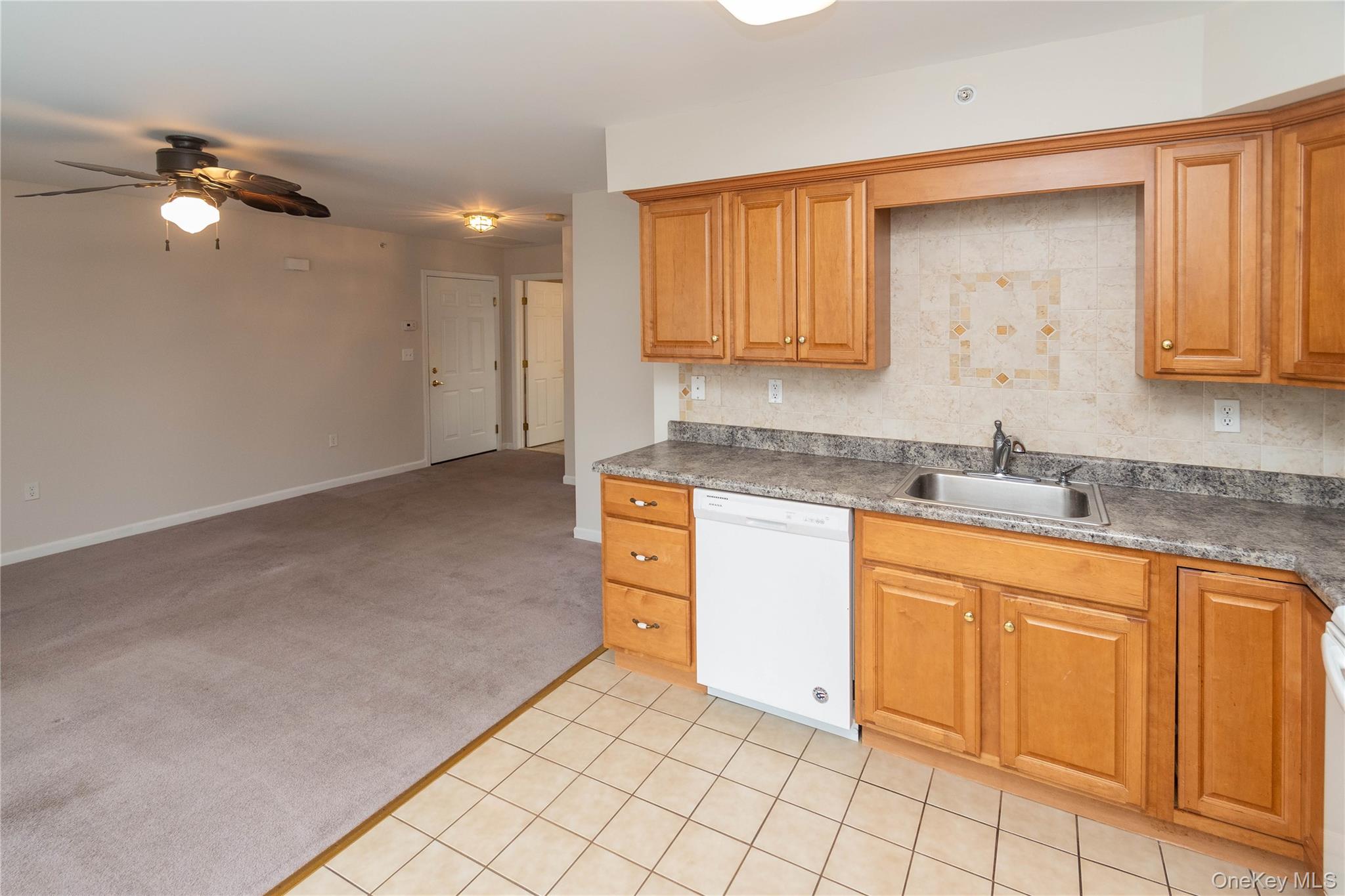 70 Aveonis Court Fishkill, NY 12524 - Photo 18 of 19 Kitchen featuring light colored carpet, white dishwasher, brown cabinets, ceiling fan, and open floor plan