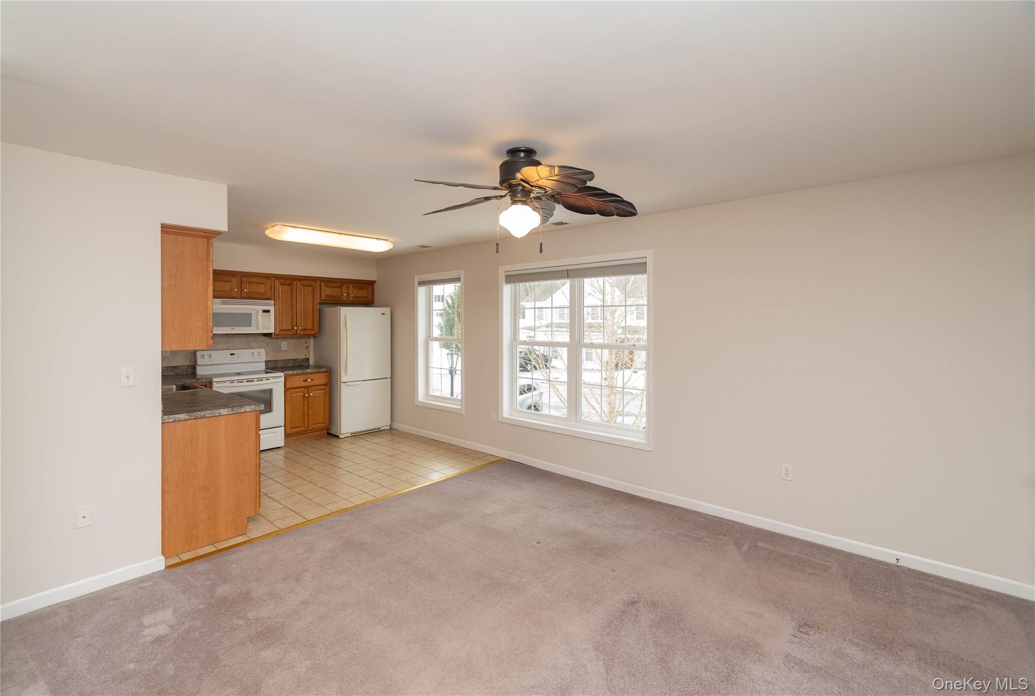 70 Aveonis Court Fishkill, NY 12524 - Photo 19 of 19 Kitchen with white appliances, brown cabinetry, light colored carpet, open floor plan, and backsplash