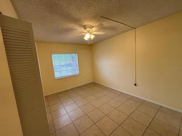 a view of a livingroom with a chandelier fan and windows