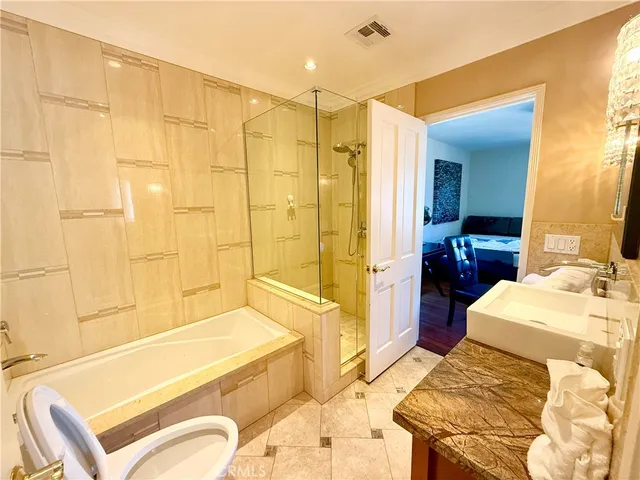 a bathroom with a tub a sink a mirror and a shower