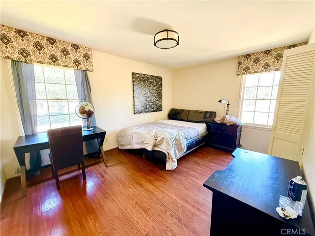 a bedroom with a bed and wooden floor