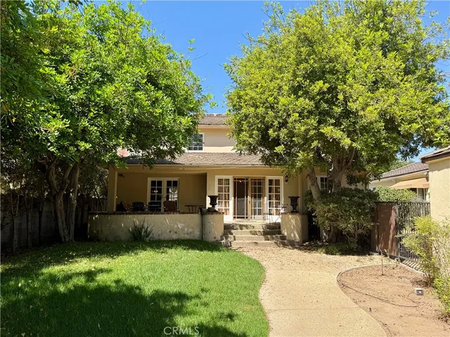 a front view of a house with a yard and green space