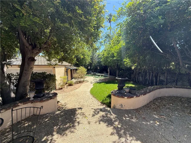 a view of a backyard with plants and a slide