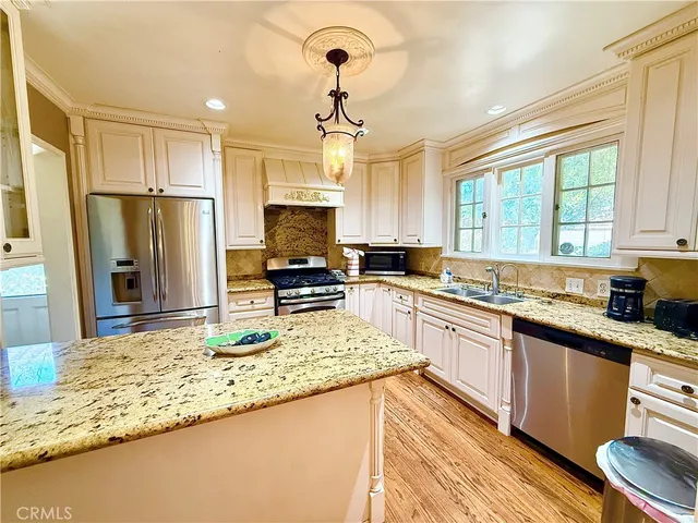 a kitchen with stainless steel appliances granite countertop a sink refrigerator and microwave