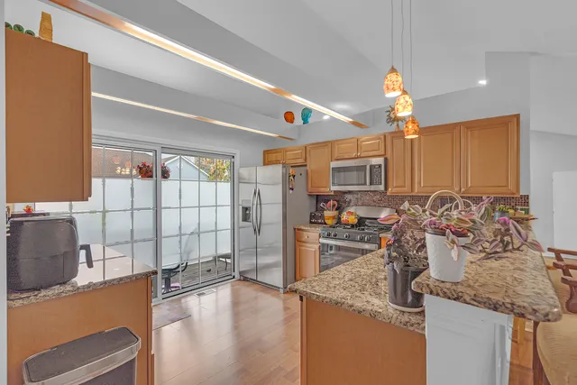 a kitchen with stainless steel appliances granite countertop a sink and a refrigerator