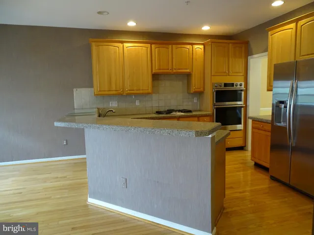 a kitchen with stainless steel appliances granite countertop a sink a stove and a refrigerator