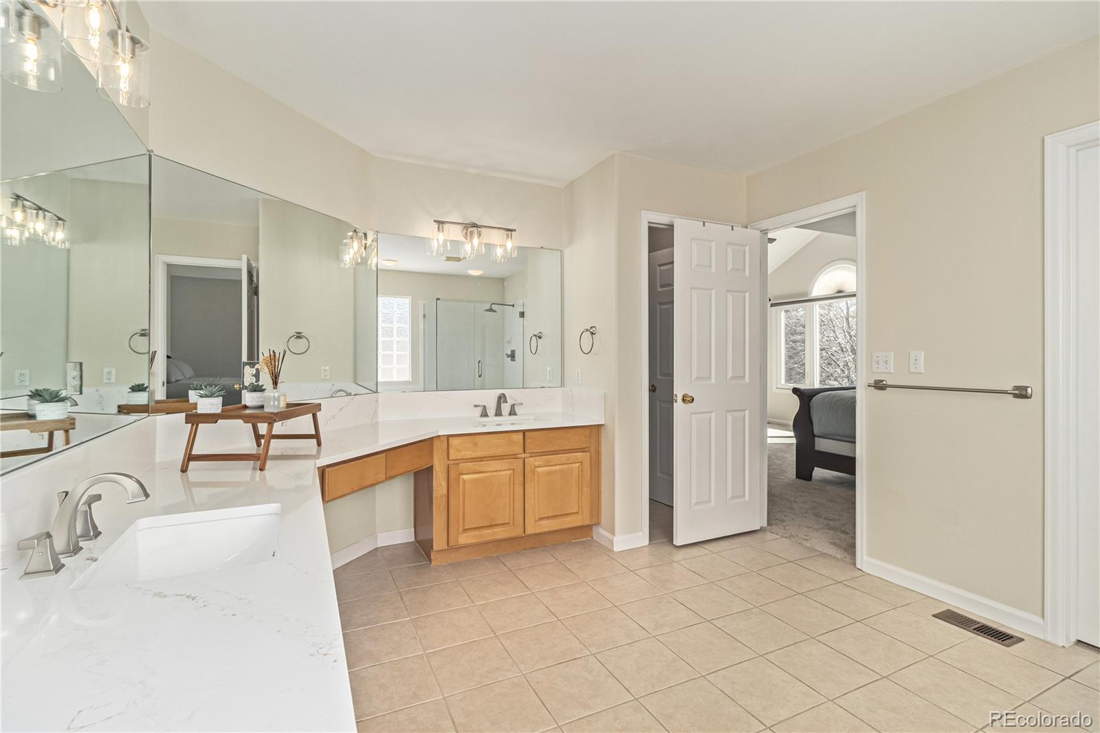 10152 Knoll Circle Highlands Ranch, CO 80130 - Photo 16 of 34 a large white bathroom with a granite countertop sink mirror and bathtub
