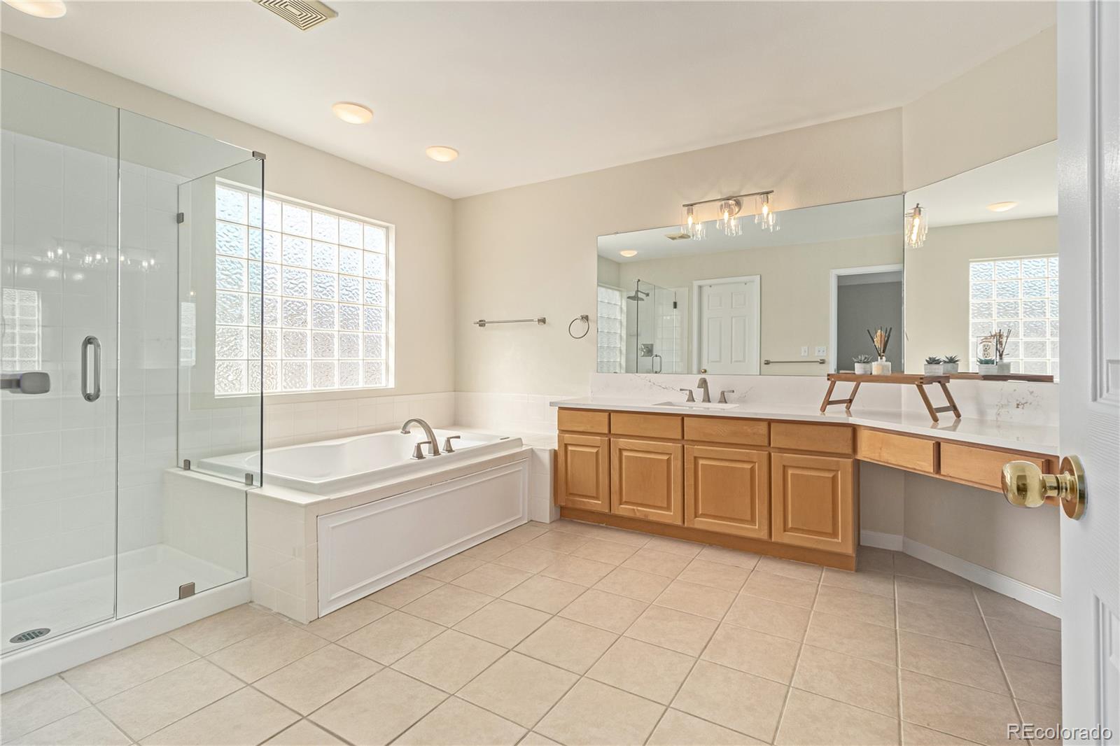 10152 Knoll Circle Highlands Ranch, CO 80130 - Photo 17 of 34 a large spacious bathroom with a double vanity sink a mirror and a bathtub
