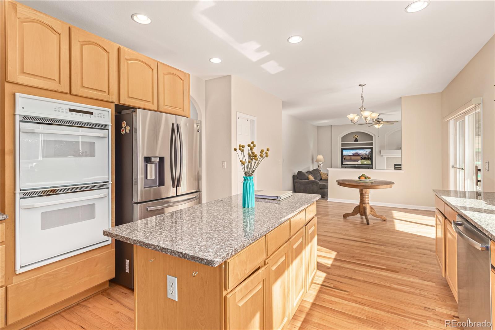 10152 Knoll Circle Highlands Ranch, CO 80130 - Photo 10 of 34 a kitchen with stainless steel appliances granite countertop a refrigerator a stove and a sink with cabinets