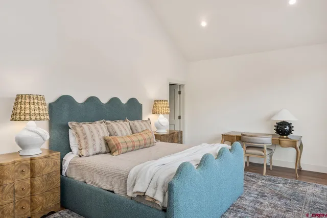 a bedroom with a bed and a lamp on dresser