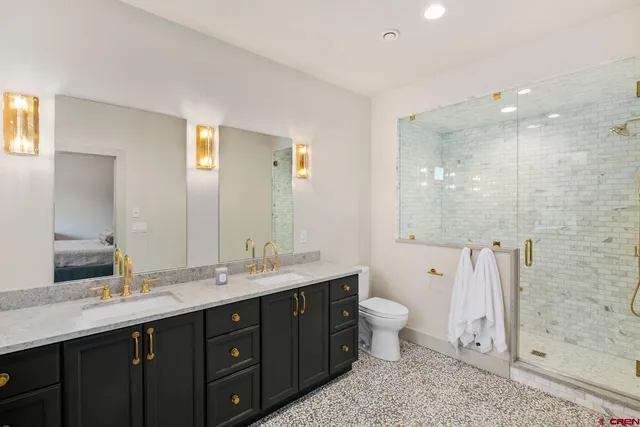 a bathroom with a double vanity sink toilet and shower