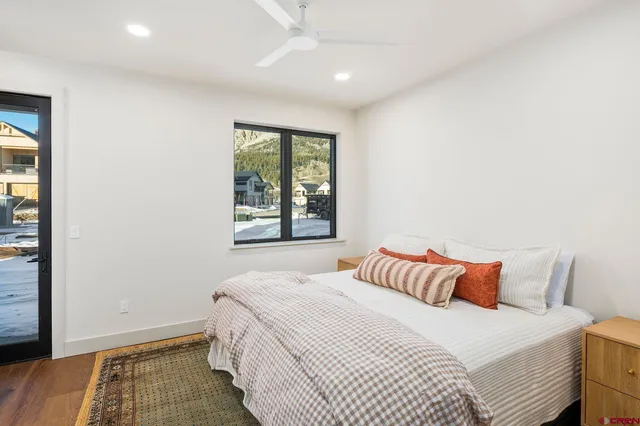 a bedroom with a bed and wooden floor