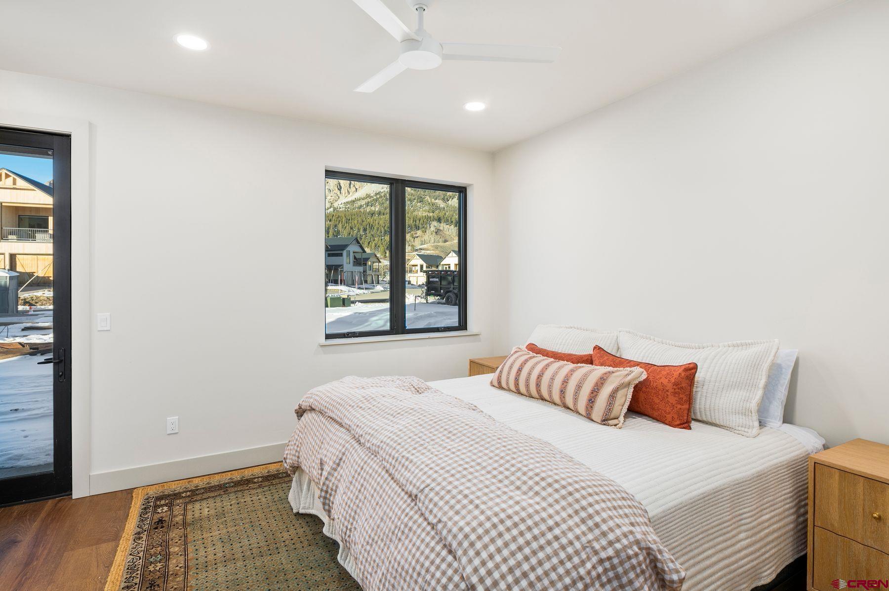 180 Elk Valley Road, Unit 116 Crested Butte, CO 81224 - Photo 18 of 26 a bedroom with a bed and wooden floor