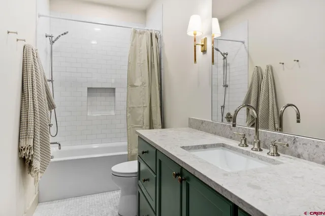 a bathroom with a granite countertop sink toilet and shower