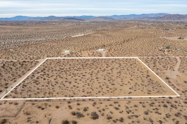an aerial view of a house with a mountain in the background