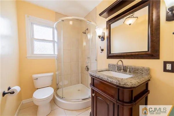 a bathroom with a granite countertop toilet sink and mirror