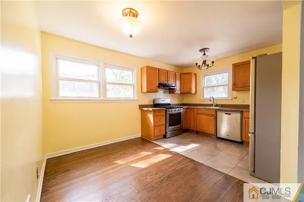 a kitchen with granite countertop a sink cabinets and stainless steel appliances