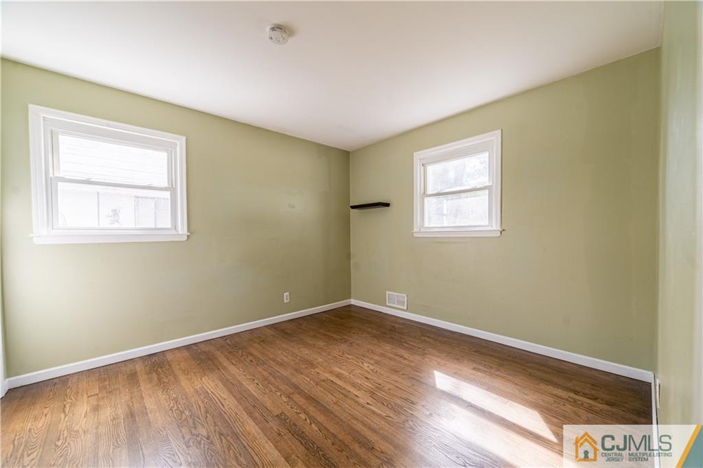 16 Homes Street Edison, NJ 08817 - Photo 4 of 21 an empty room with wooden floor and windows