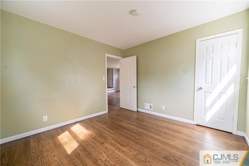 16 Homes Street Edison, NJ 08817 - Photo 5 of 21 an empty room with wooden floor and windows