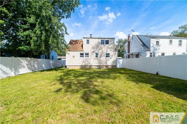 a view of a backyard with table and chairs and wooden fence