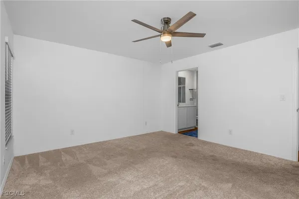 an empty room with a fan and a window