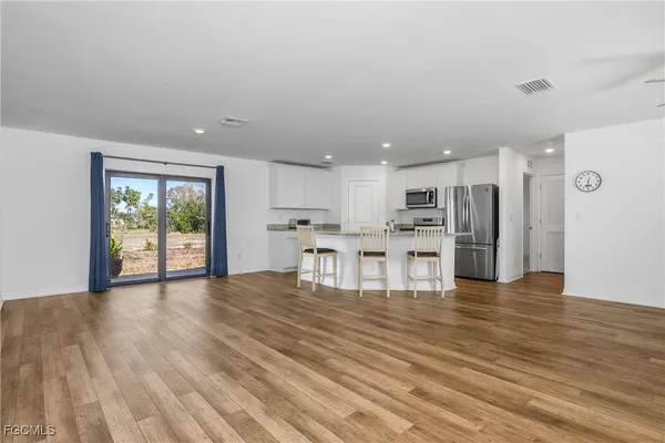 a view of kitchen with stainless steel appliances refrigerator microwave and dining table