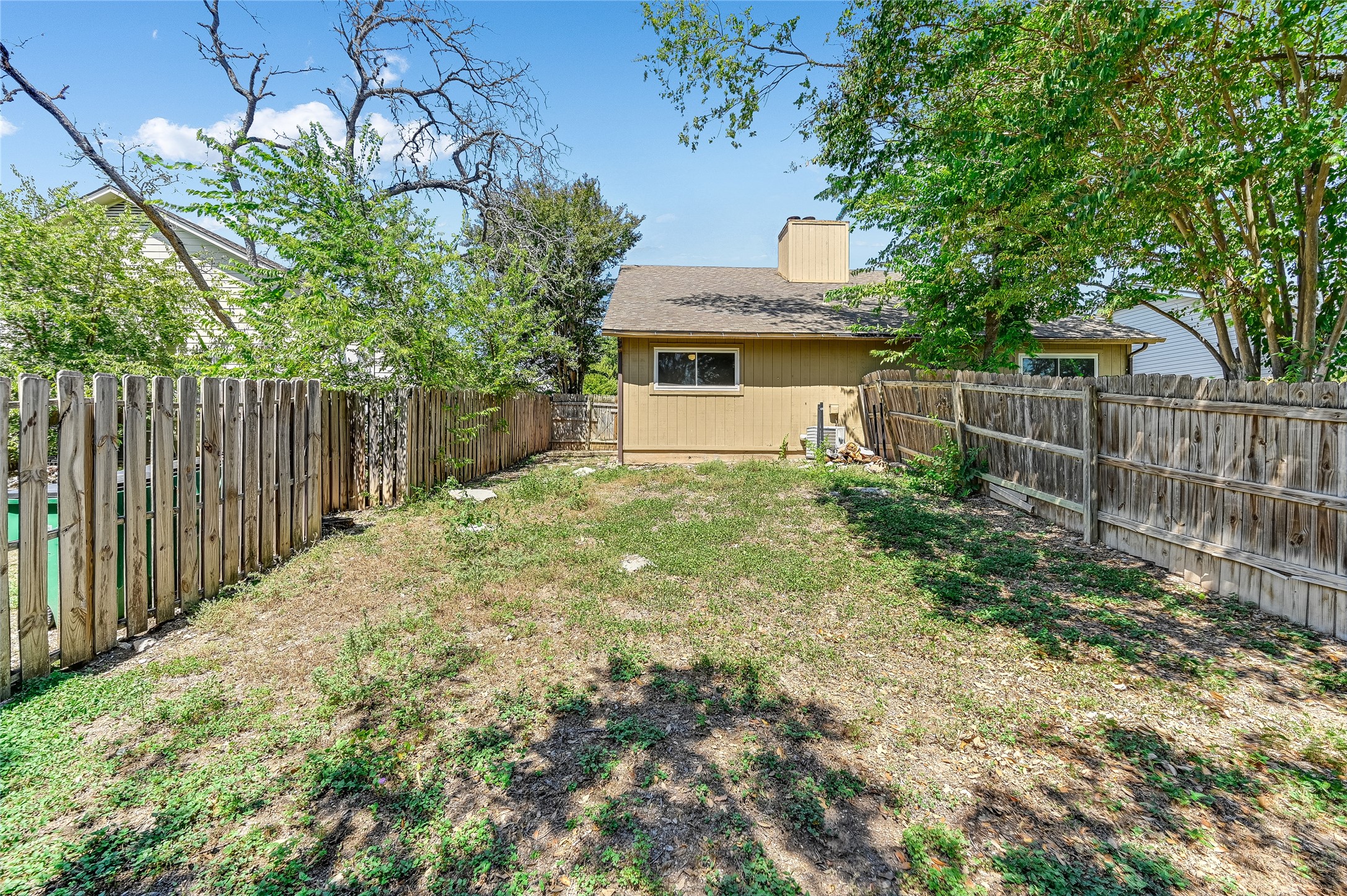 526 Cutty Trail, Unit B Lakeway, TX 78734 - Photo 2 of 10 Expansive backyard featuring natural ground cover and a wood privacy fence