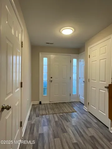an empty room with wooden floor and a bathroom