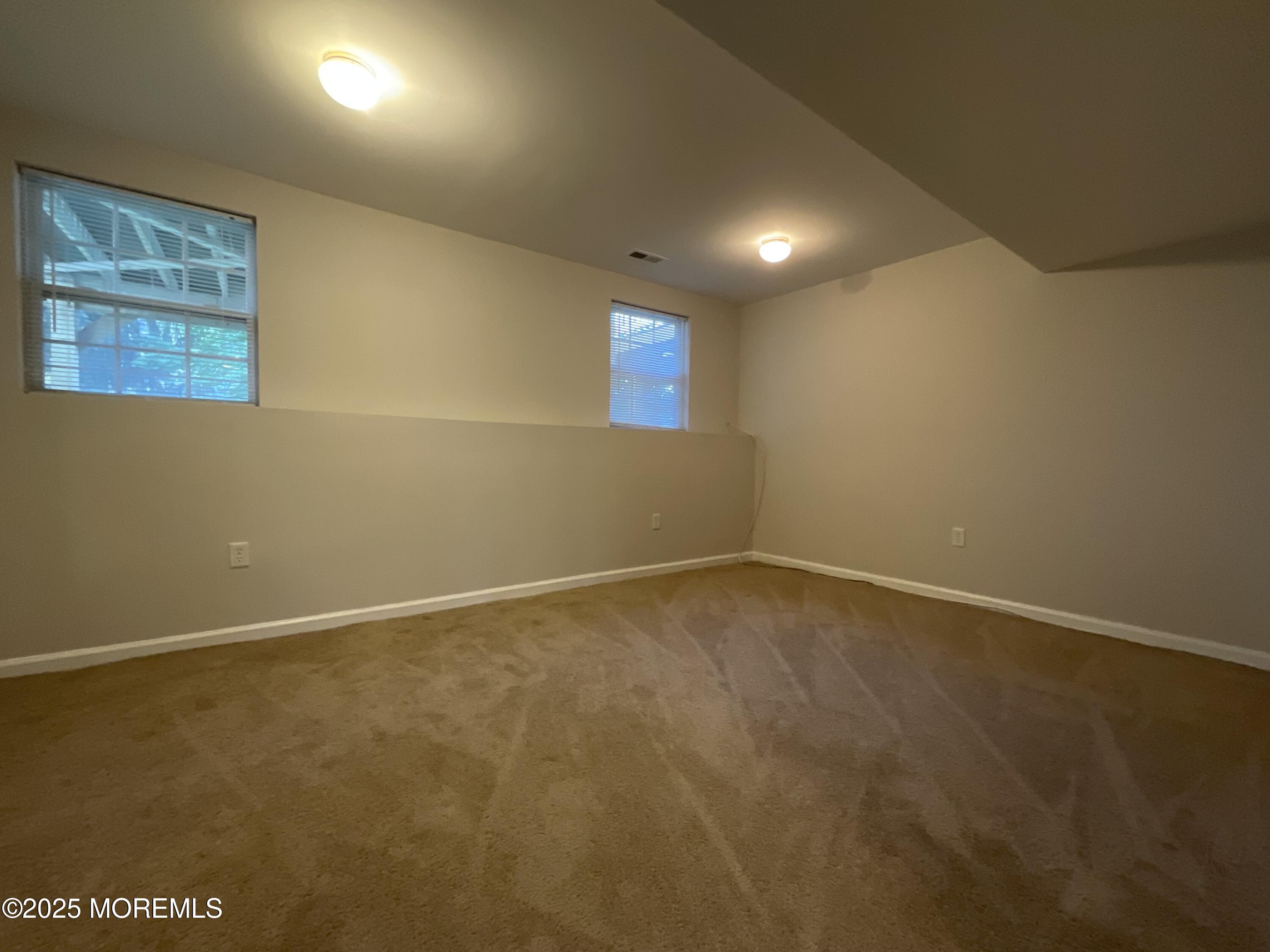 12 Abby Road, Unit 75 Farmingdale, NJ 07727 - Photo 5 of 20 an empty room with a projector and windows