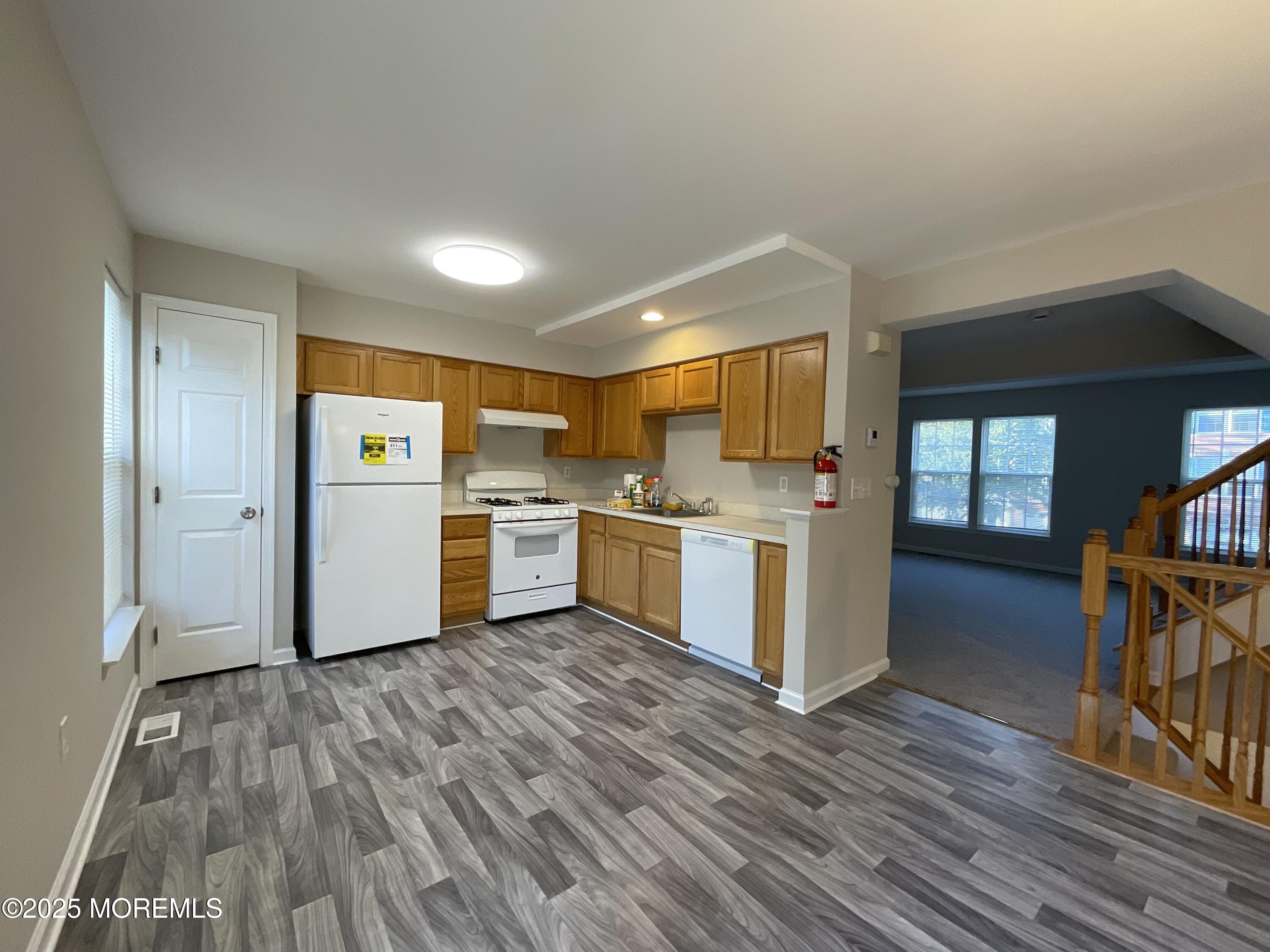 12 Abby Road, Unit 75 Farmingdale, NJ 07727 - Photo 9 of 20 a kitchen with a refrigerator and wooden floor