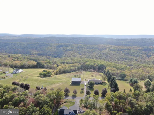 an aerial view of a house with yard and mountain view in back