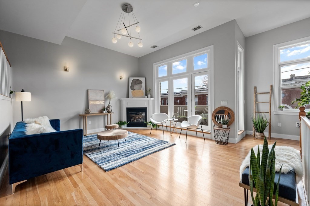 a living room with fireplace furniture and a large window