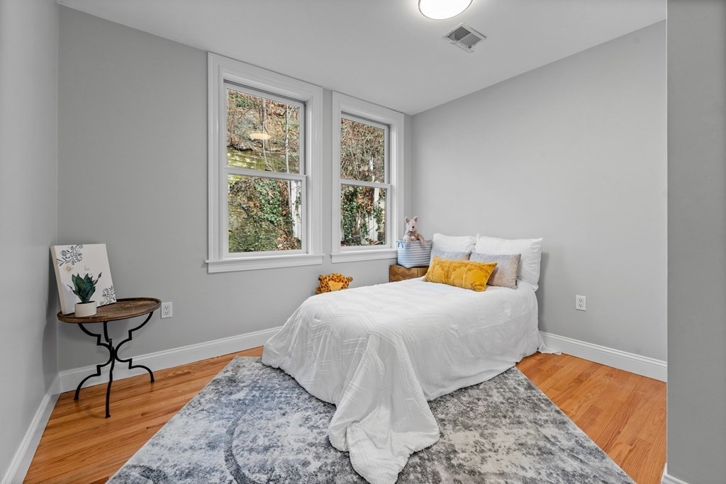 39 Leamington Road, Unit 39 Boston, MA 02135 - Photo 23 of 32 a bedroom with a bed and wooden floor