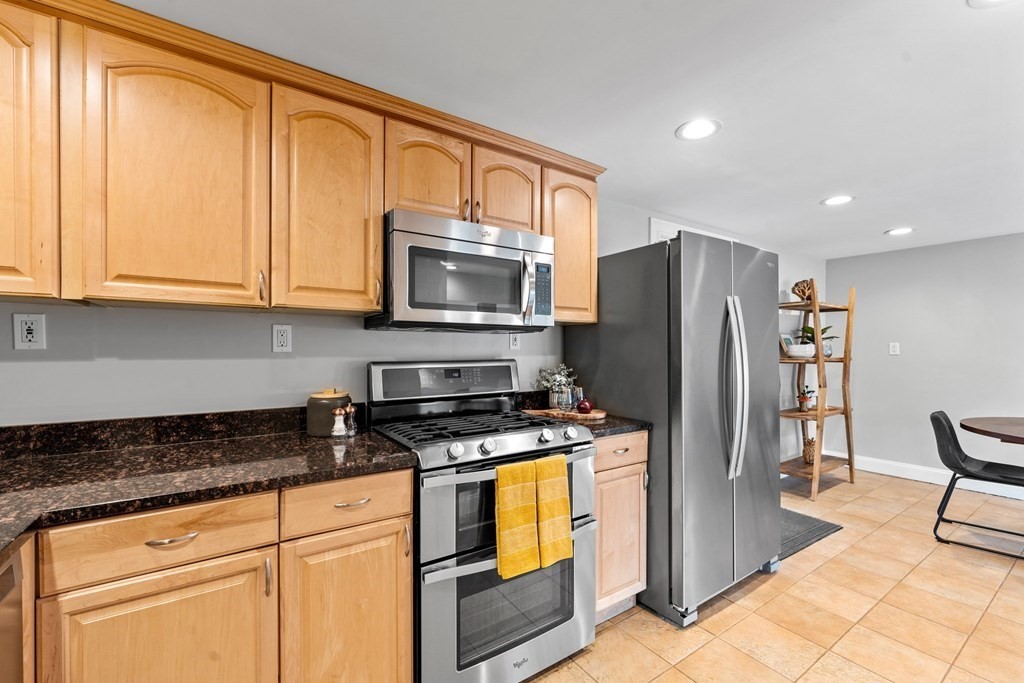 39 Leamington Road, Unit 39 Boston, MA 02135 - Photo 9 of 32 a kitchen with granite countertop a refrigerator and a stove top oven