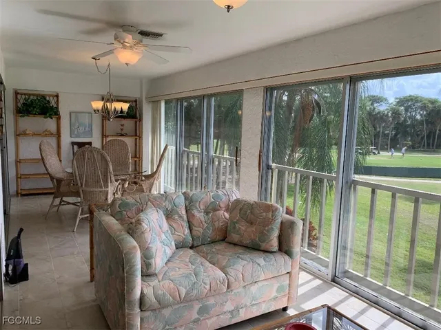 a living room with furniture and a floor to ceiling window