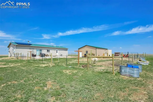 a view of a big house with a big yard and large trees