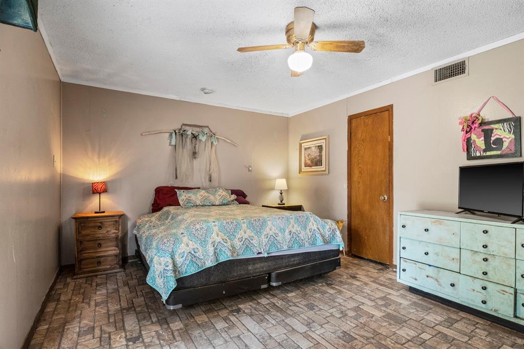 504 East 3rd Street Mount Pleasant, TX 75455 - Photo 13 of 28 a bedroom with a bed and dresser