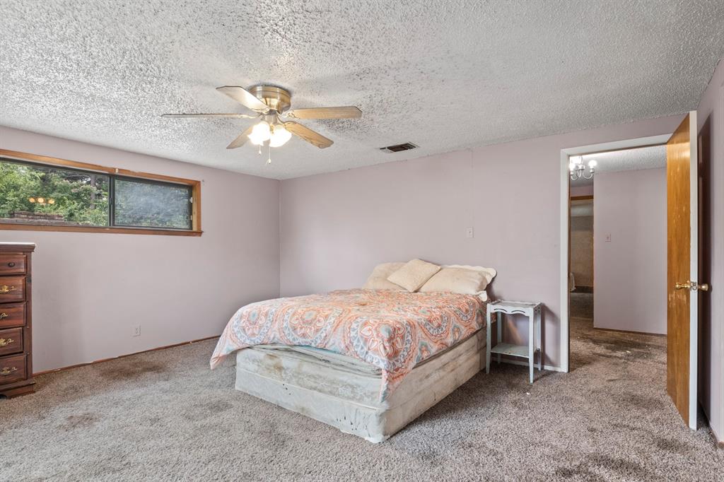 504 East 3rd Street Mount Pleasant, TX 75455 - Photo 22 of 28 a bedroom with a bed and a chandelier