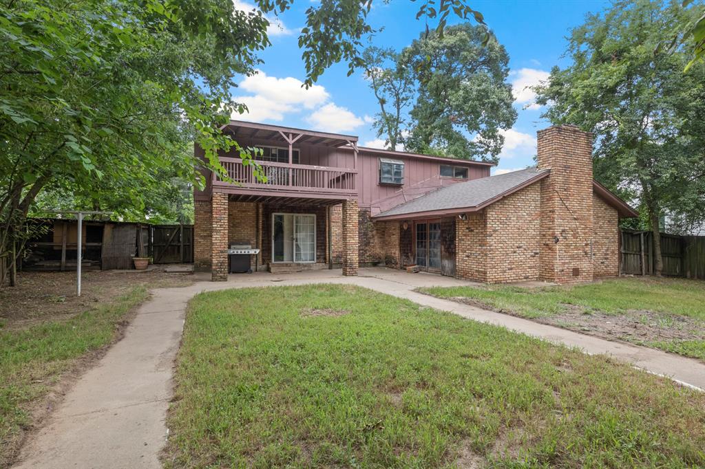504 East 3rd Street Mount Pleasant, TX 75455 - Photo 24 of 28 a view of a yard with table and chairs under an umbrella