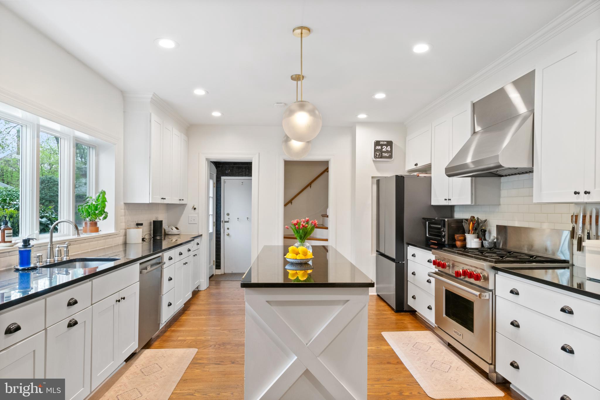 211 Lambeth Road Baltimore, MD 21218 - Photo 15 of 55 a kitchen with stainless steel appliances kitchen island granite countertop a sink a stove cabinets counter space and a window