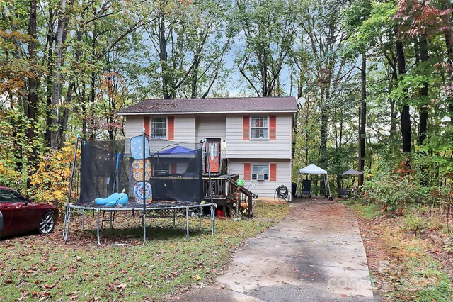 a view of house with a backyard and chairs