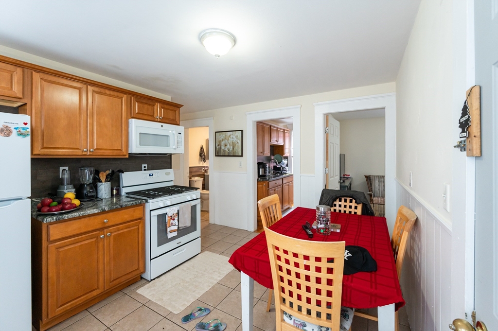 18 Edson Street Lowell, MA 01851 - Photo 20 of 41 a kitchen with stainless steel appliances granite countertop a refrigerator sink stove microwave and cabinets