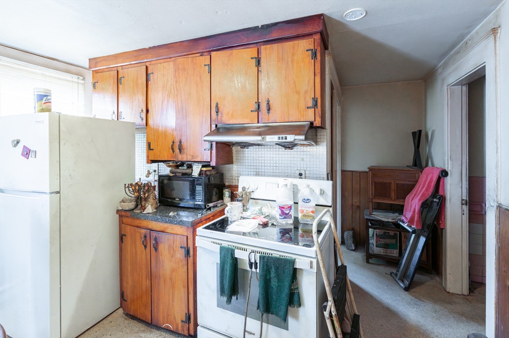 18 Edson Street Lowell, MA 01851 - Photo 22 of 41 a kitchen with a refrigerator a stove a sink dishwasher and a refrigerator with wooden floor