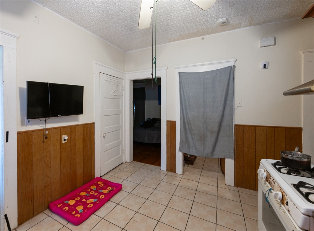 18 Edson Street Lowell, MA 01851 - Photo 9 of 41 a view of kitchen with furniture flat screen tv and refrigerator