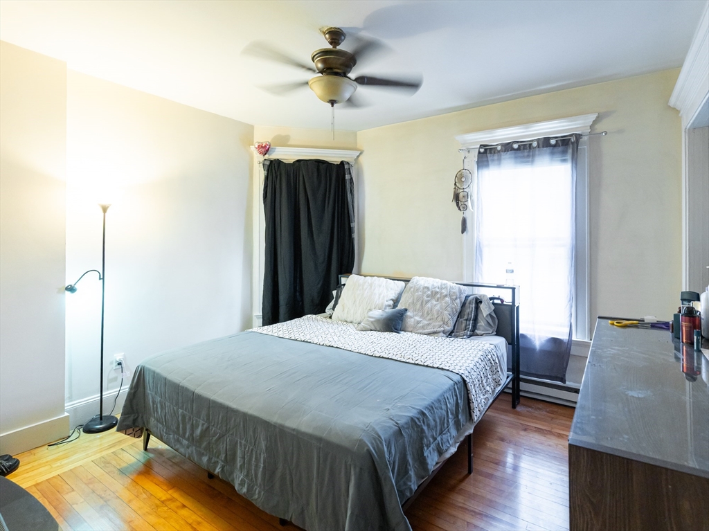 18 Edson Street Lowell, MA 01851 - Photo 10 of 41 a bedroom with a bed and a chandelier