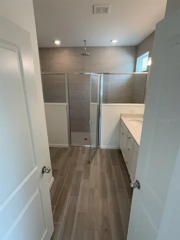 a view of an empty room with wooden floor and staircase