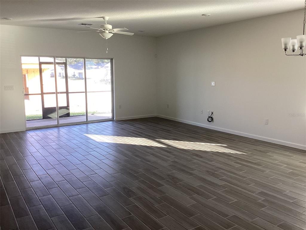 7898 Southwest 74th Loop Ocala, FL 34481 - Photo 3 of 23 an empty room with wooden floor and windows