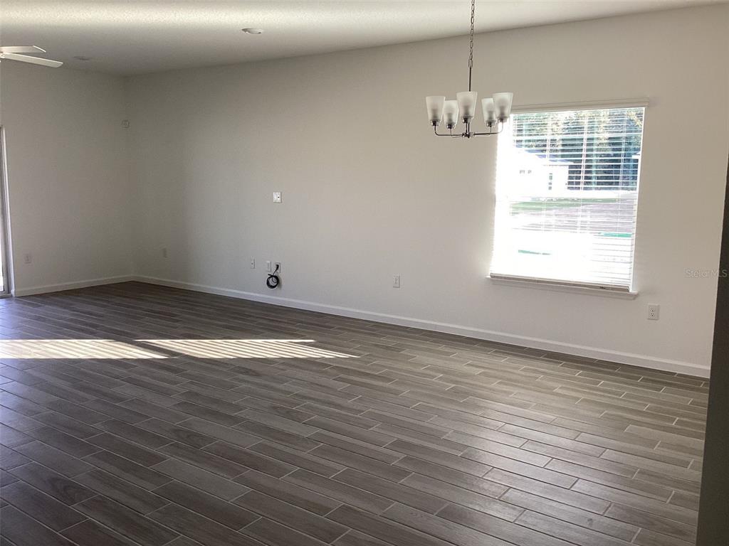 7898 Southwest 74th Loop Ocala, FL 34481 - Photo 4 of 23 a view of empty room with wooden floor and fan